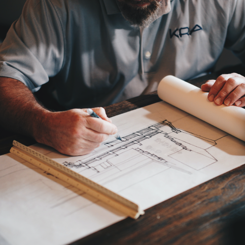 Homme dessinant un plan de chantier